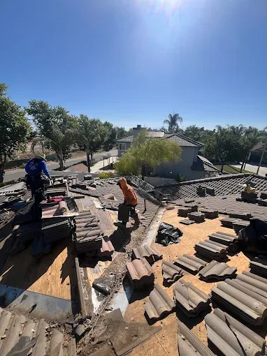 Professional inspecting a metal roof for maintenance in Southern California