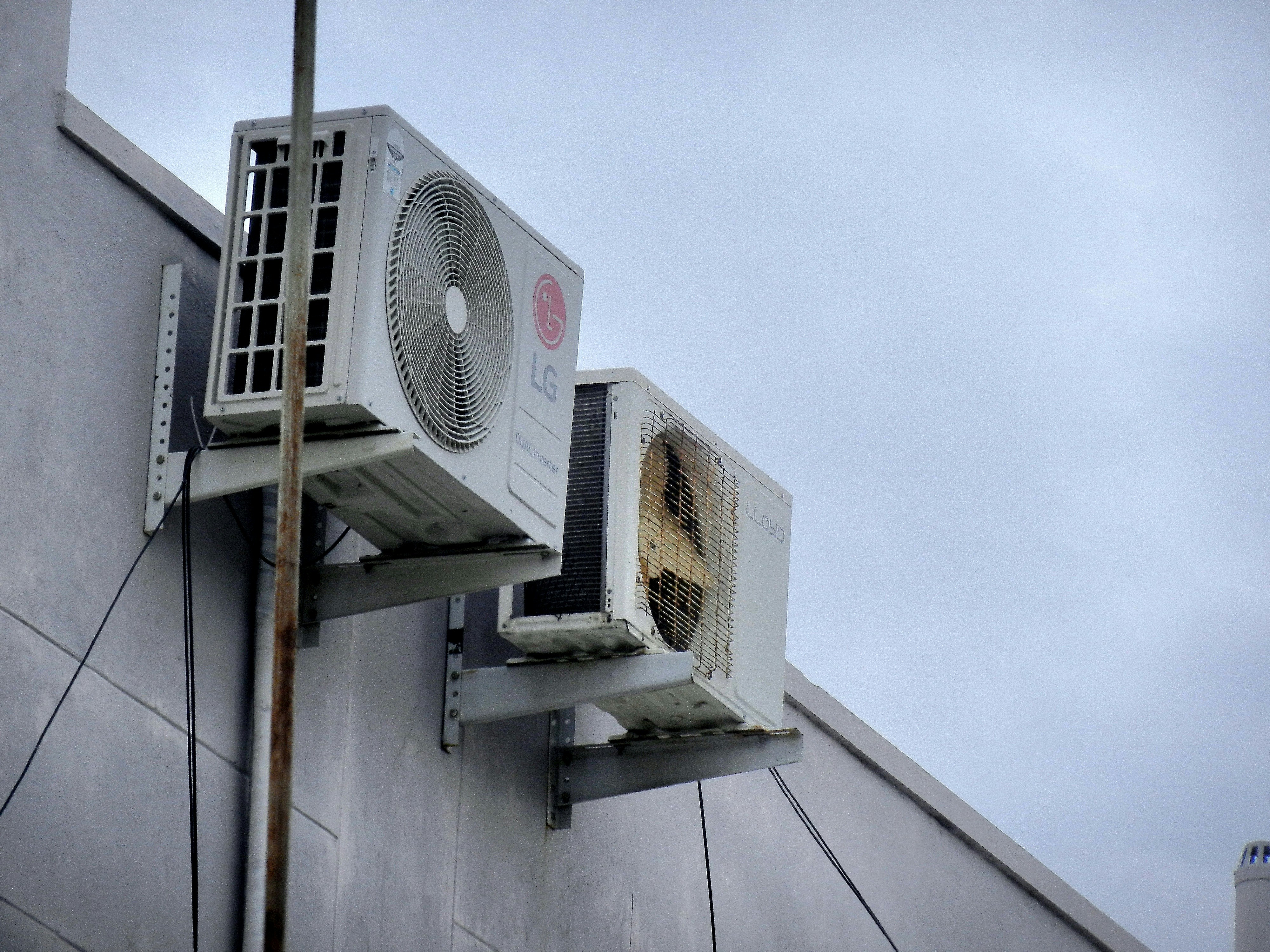 Wall-mounted outdoor AC units showing why licensed contractors are essential for safe, secure, and code-compliant AC installation.