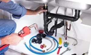 Plumber ensuring quality workmanship while repairing a complex plumbing system, underscoring expertise and commitment to service