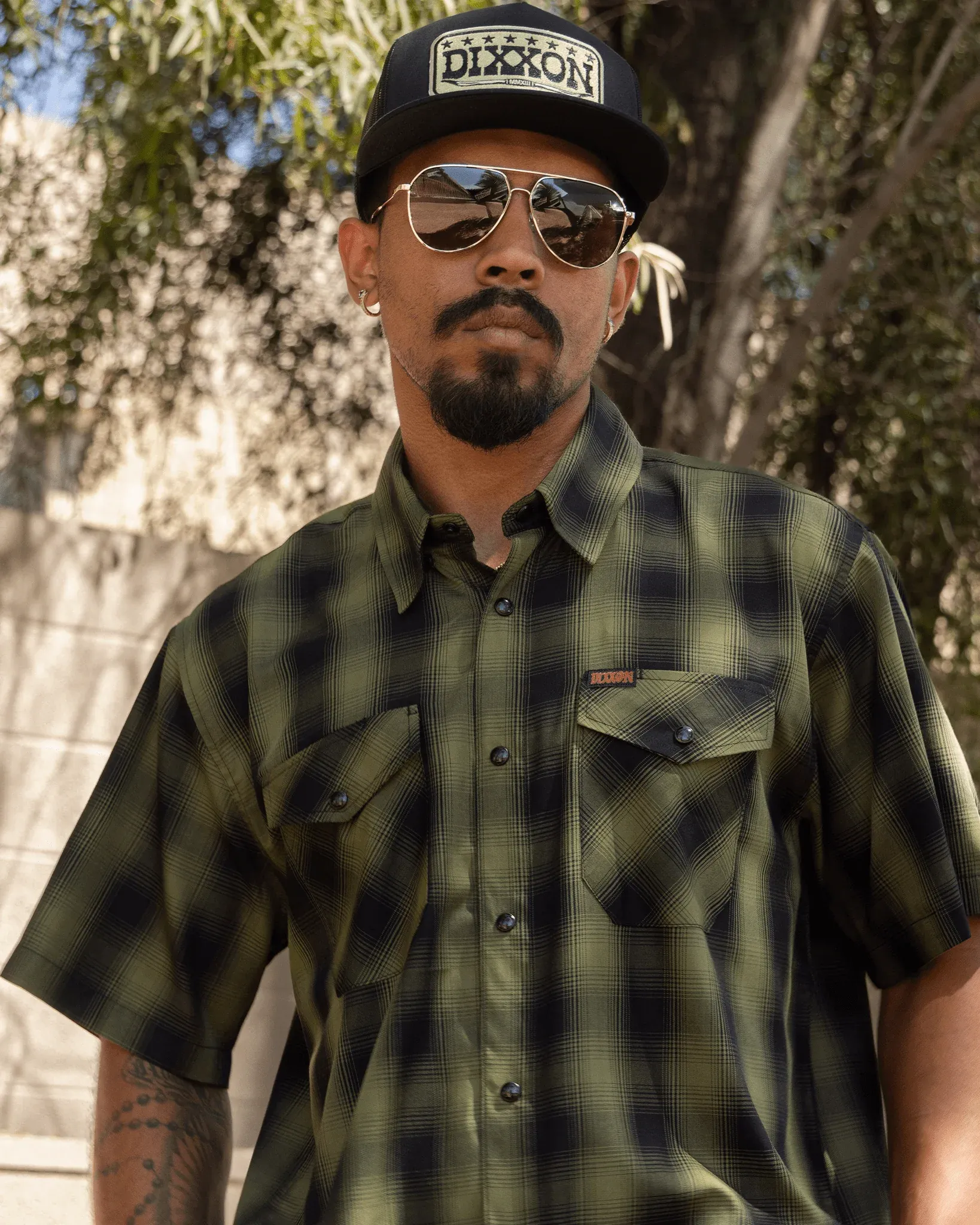Man in Lone Wolf Heritage bamboo short sleeve shirt, aviators, and Dixxon hat.