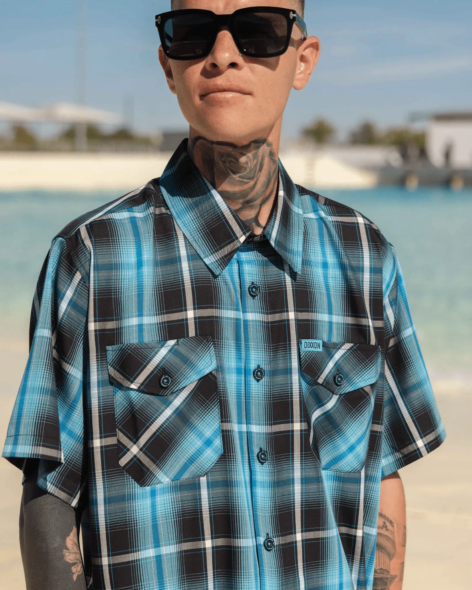 Man wearing Piranha short sleeve bamboo shirt and sunglasses near the water.
