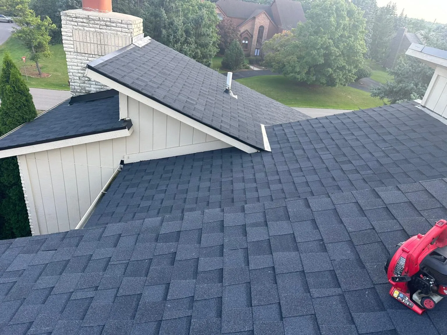 Homeowner applying a tarp on a damaged roof to limit water entry during a storm