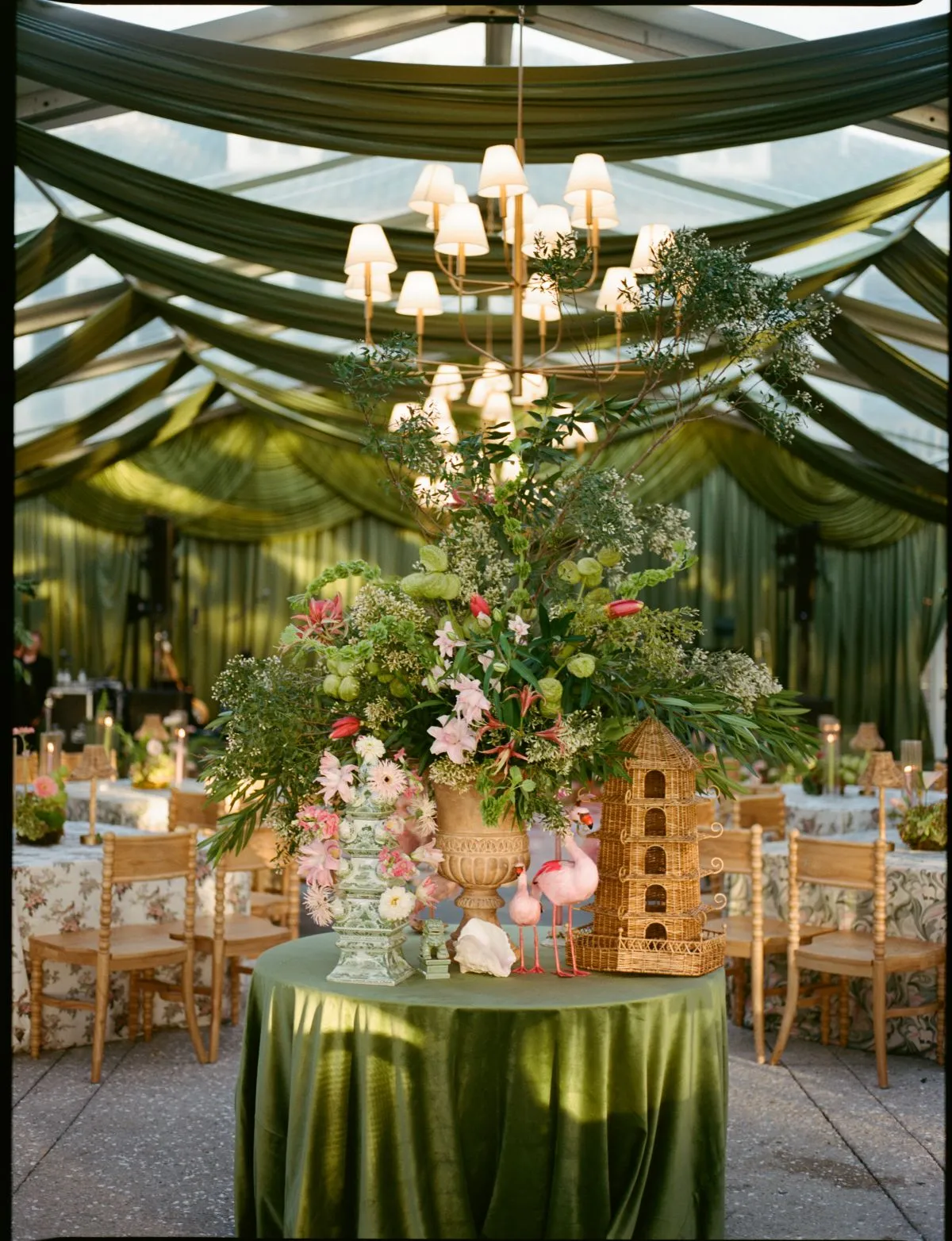 Round display table with green linen, oversized floral arrangement, and decorative accents for a Chesapeake event.