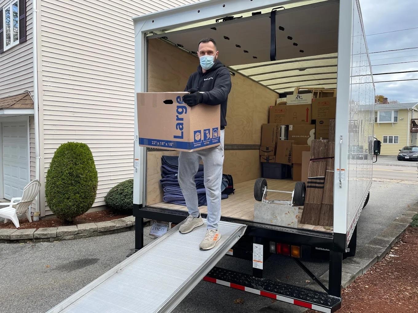 Person researching moving companies using a laptop and notebook