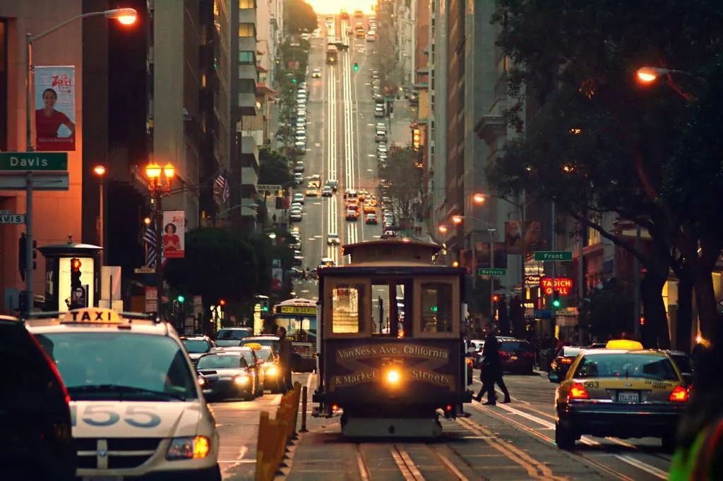 San Francisco cable car climbing a street at dusk