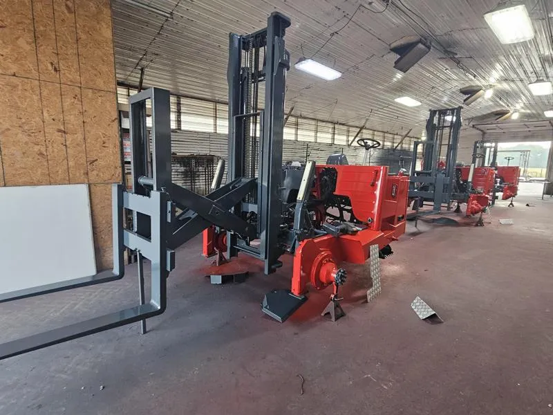 Moffett forklift lifting a load in a busy warehouse, showcasing its essential parts and functionality