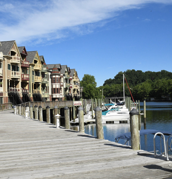 Waterfront boardwalk and colorful townhomes in Occoquan, Virginia overlooking the marina and Occoquan River on a sunny day