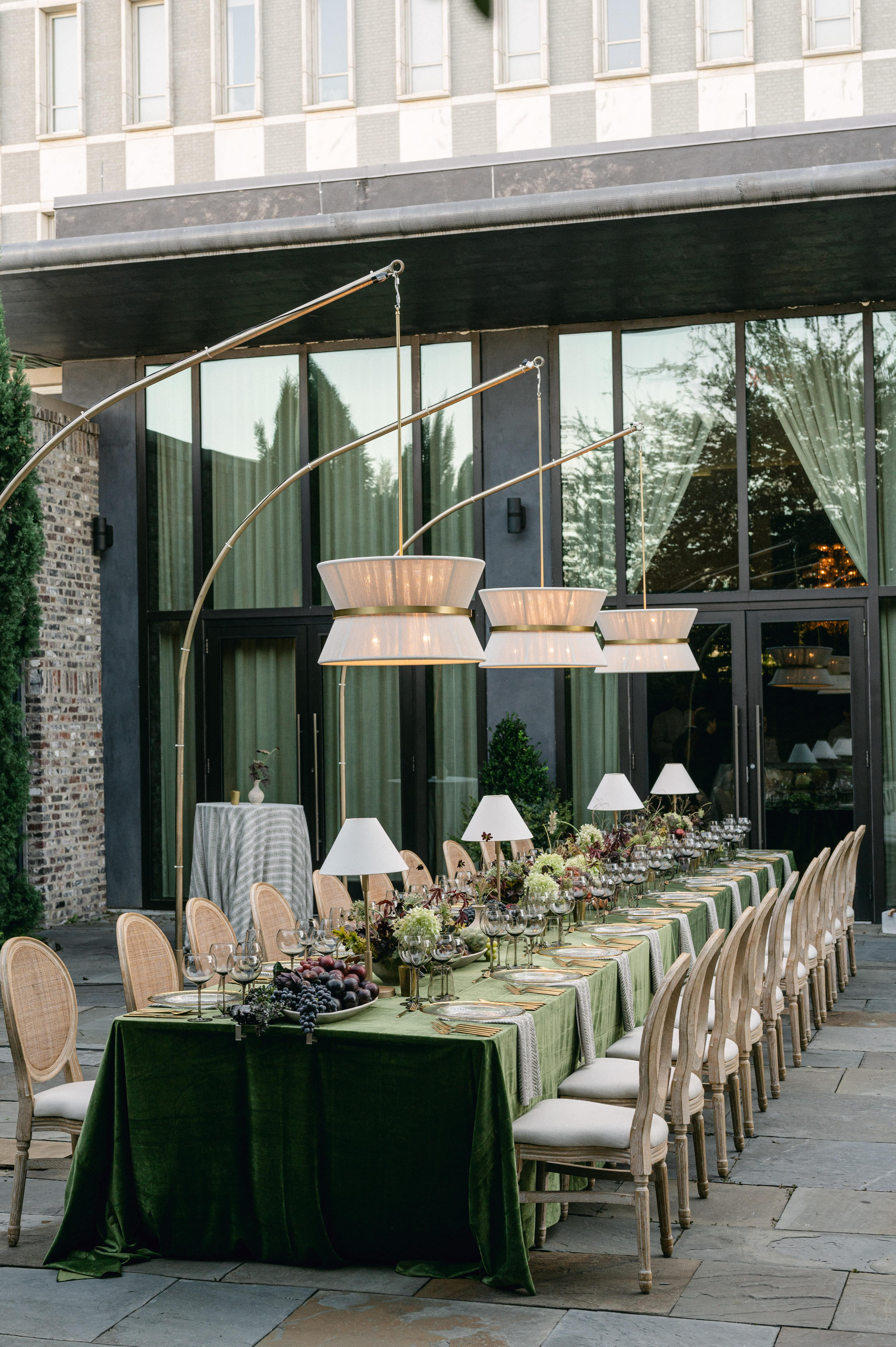 Stylish outdoor summer table with linens, vibrant floral decor, and warm lighting