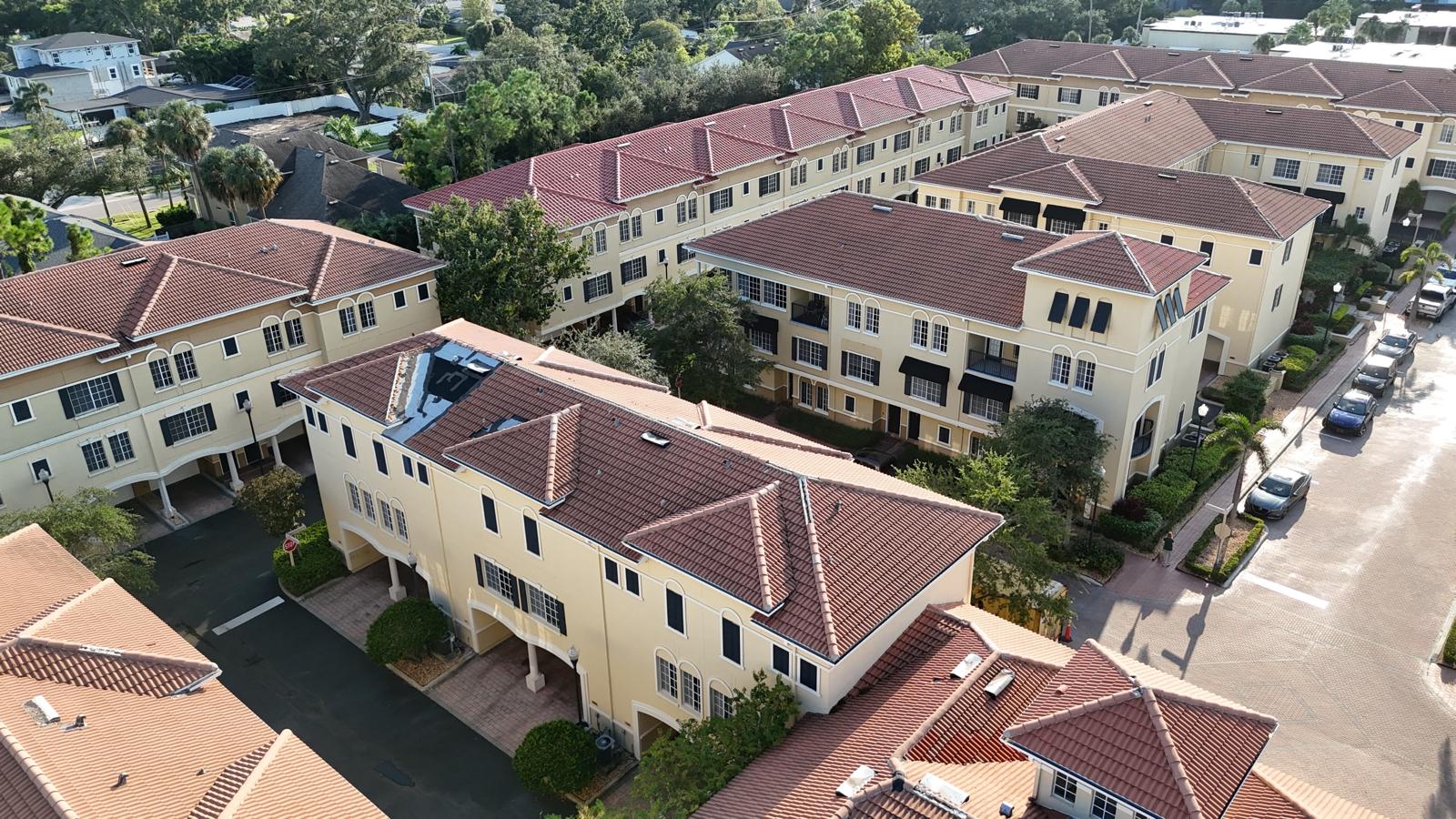 Aerial view of a Florida residential community with multiple homes featuring red tile roofs, showcasing durable roofing installation.