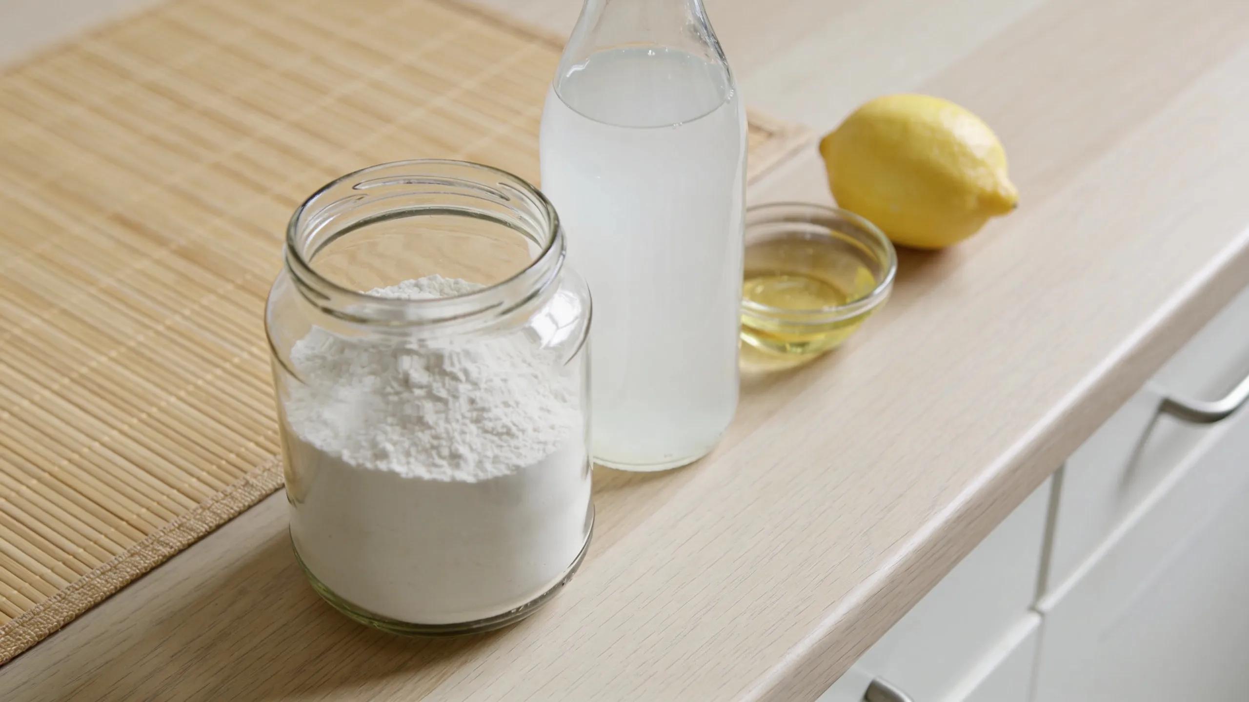 Natural stain removal ingredients next to bamboo sheets, showcasing safe cleaning methods