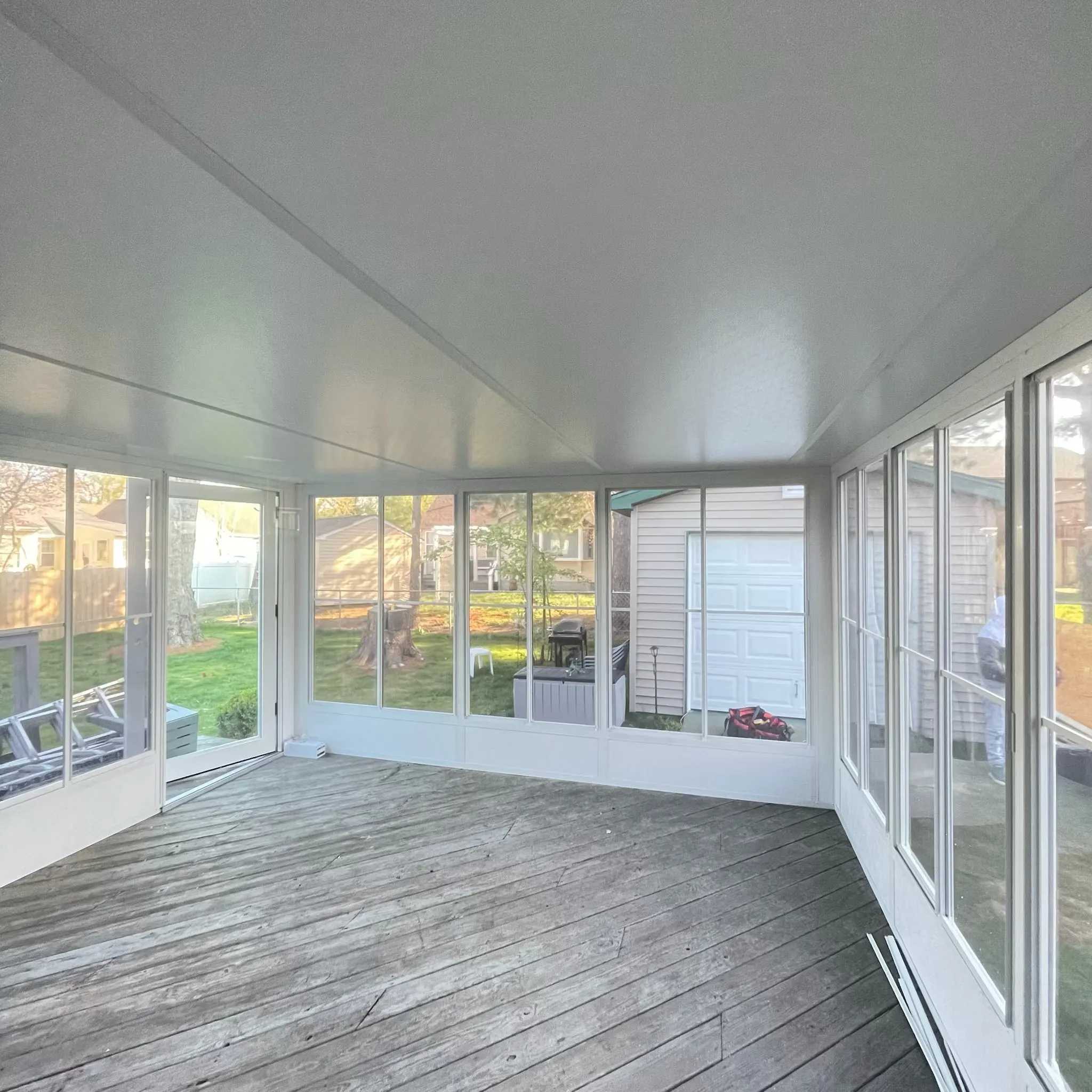 Professional sunroom contractor installing aluminum framing on a home addition