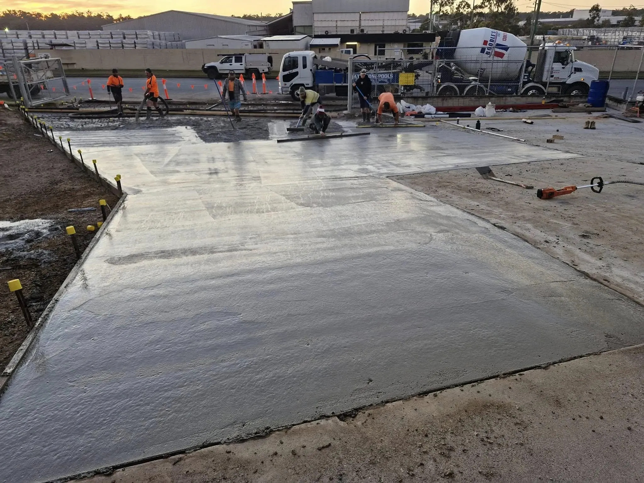 Eco-friendly construction practices with workers using recycled materials for paving, highlighting McNamara Concrete's sustainable initiatives