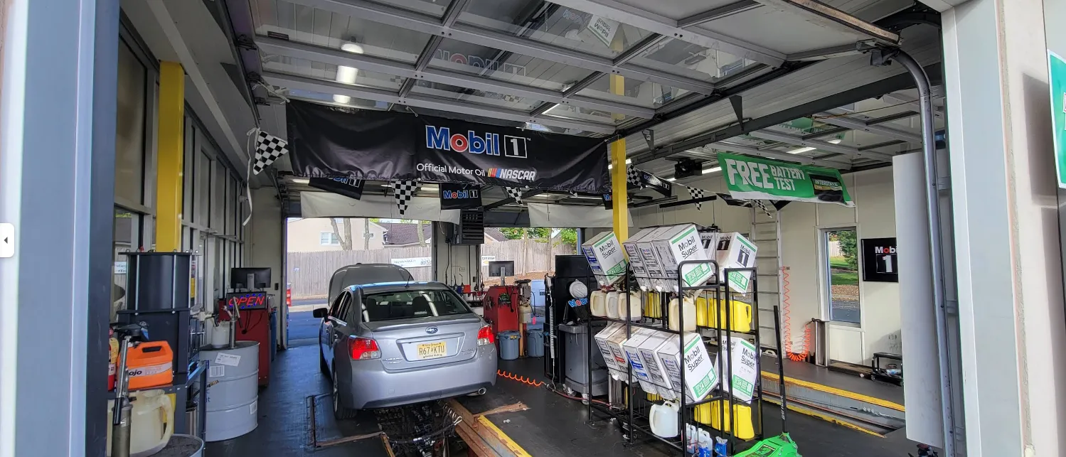 Mechanic changing oil in a garage, focused on routine vehicle maintenance and efficient service
