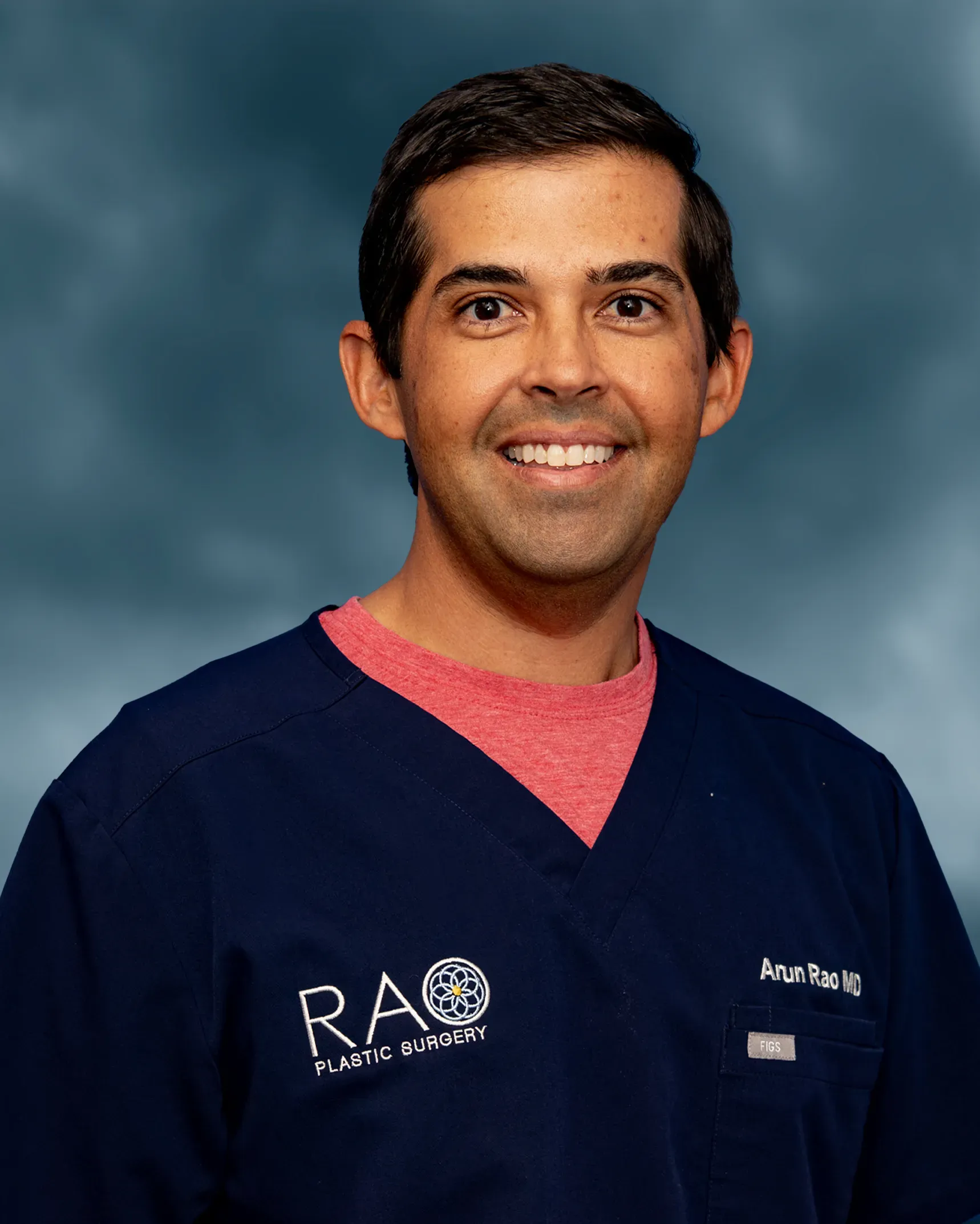 Dr. Arun Rao, board-certified plastic surgeon, in scrubs