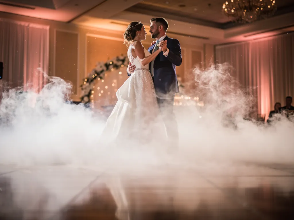 Bride and groom dancing through a low rolling dry ice cloud