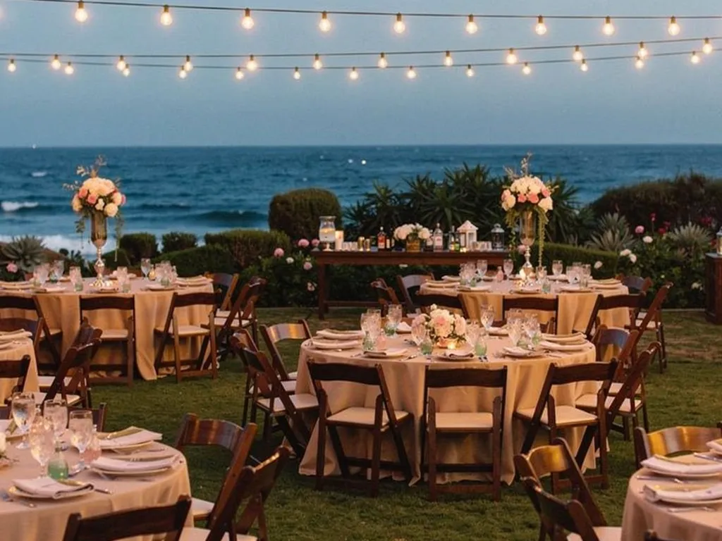 outdoor Santa Barbara wedding reception round tables with linen floral centerpieces and string lights at