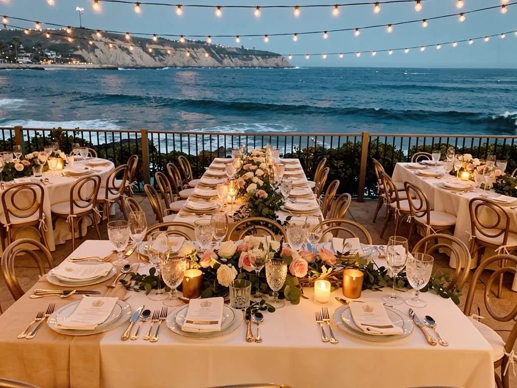 wedding reception long tables with white linens fine china and golden bistro lighting