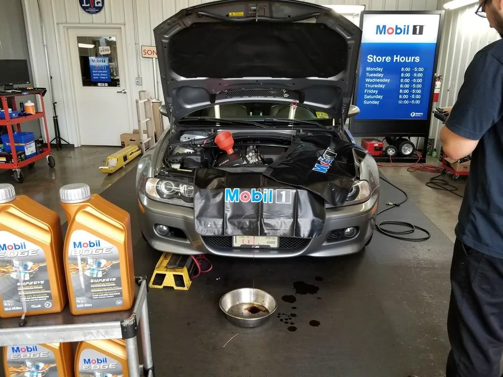 Mechanic checking oil level on dipstick of high mileage vehicle