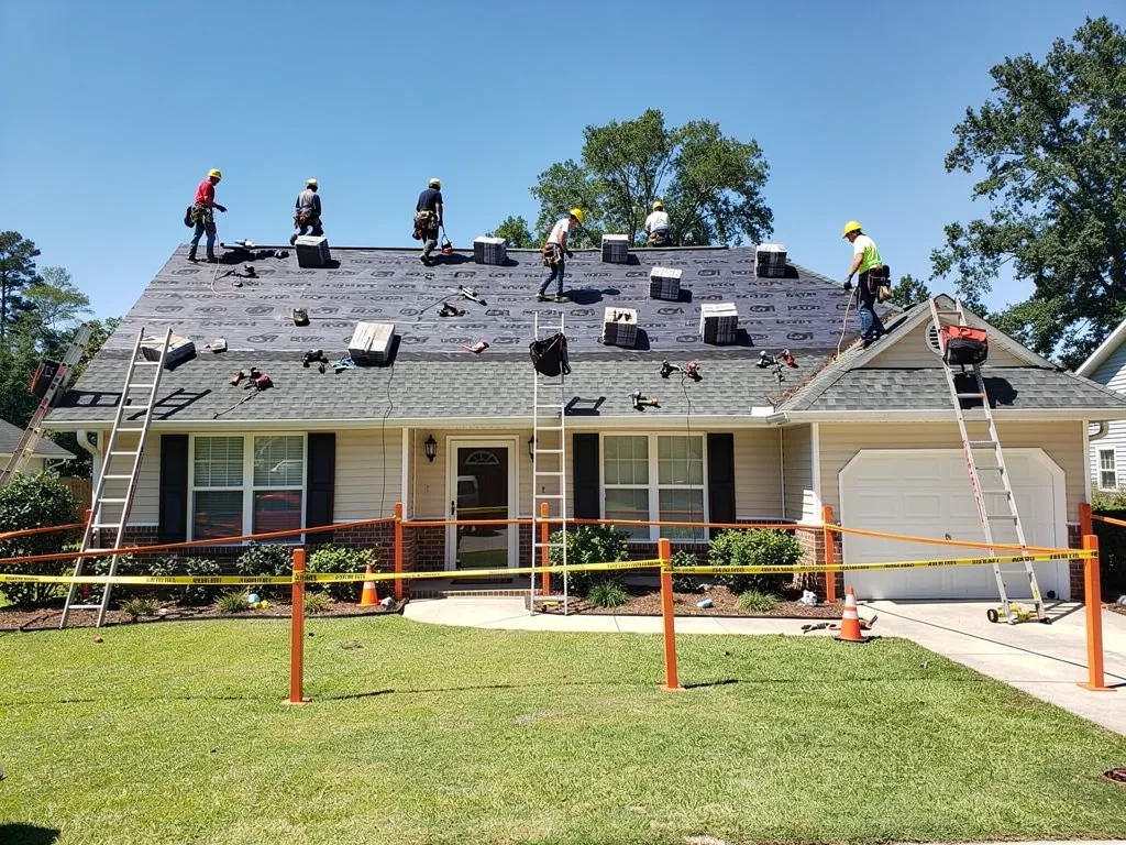Roofing crew following safety protocol with helmets and safety gear during residential roof replacement