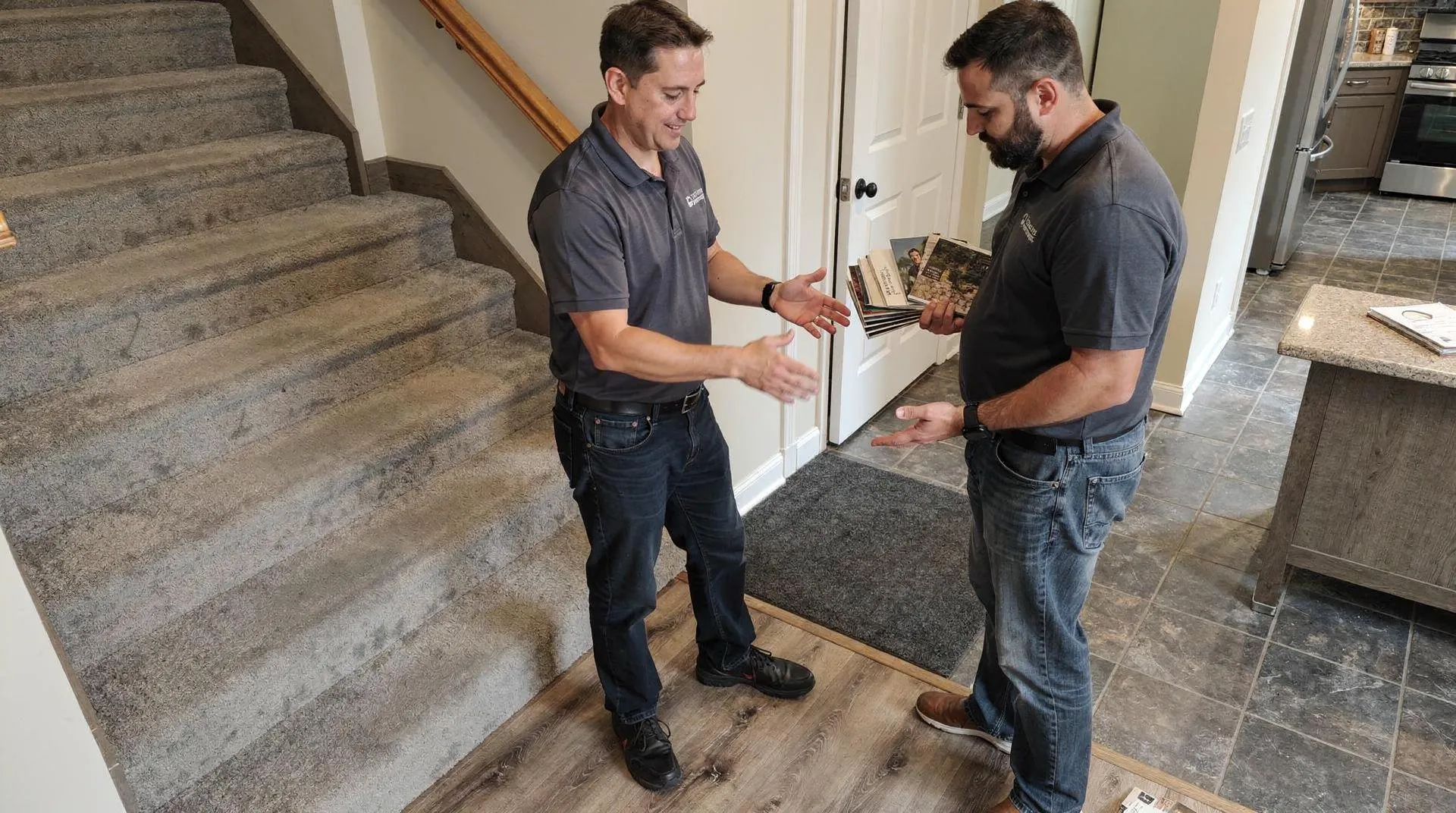 Wholesale Carpets professionals discussing flooring options during an in-home estimate.
