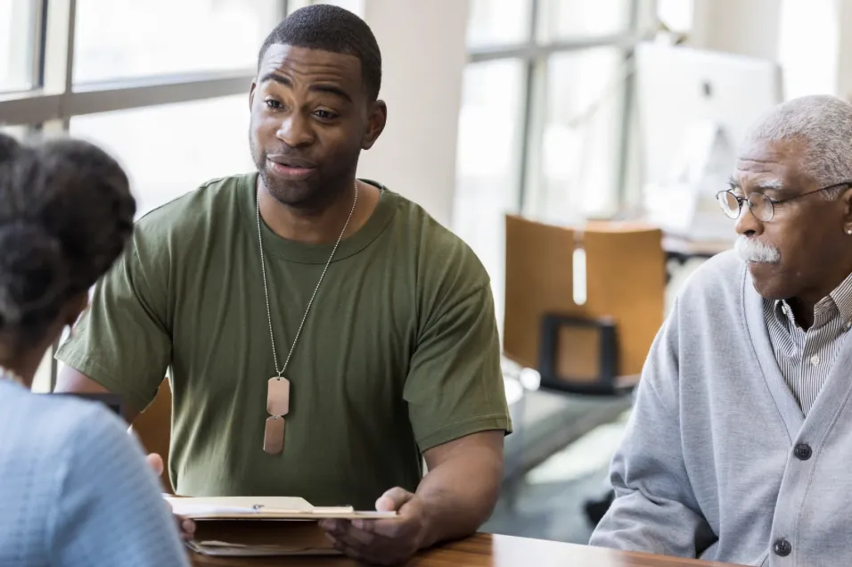 1 middle aged african-american veteran next to an older african-american male speaking with loan officerr 1 middle aged african-american veteran next to an older african-american male speaking with loan officerr