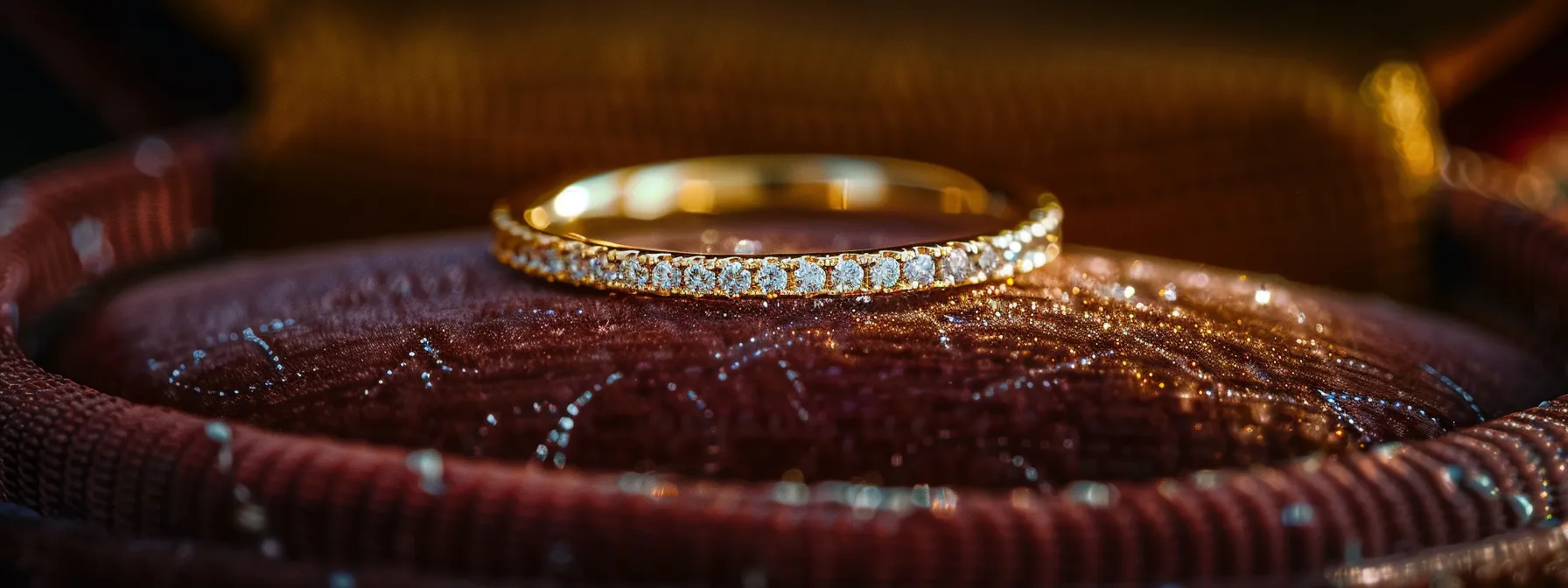 a sparkling, delicate gold wedding band displayed on a velvet cushion, reflecting elegance and sophistication.