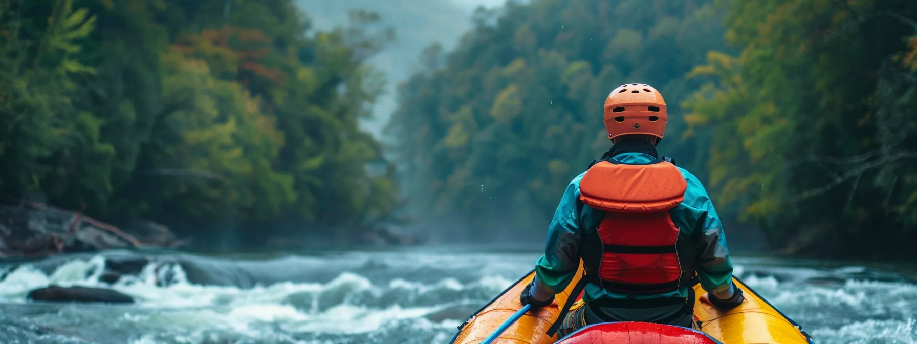 a person standing beside a brightly colored raft, wearing a helmet and life jacket, with the ocoee river rushing in the background.