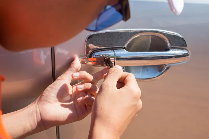 Automotive locksmith working on a car door lock or key