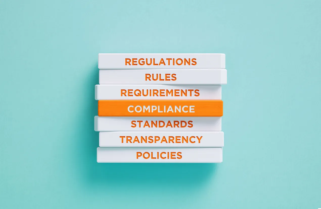 Compliance related words written wood blocks on blue background. Compliance concept in Bournemouth