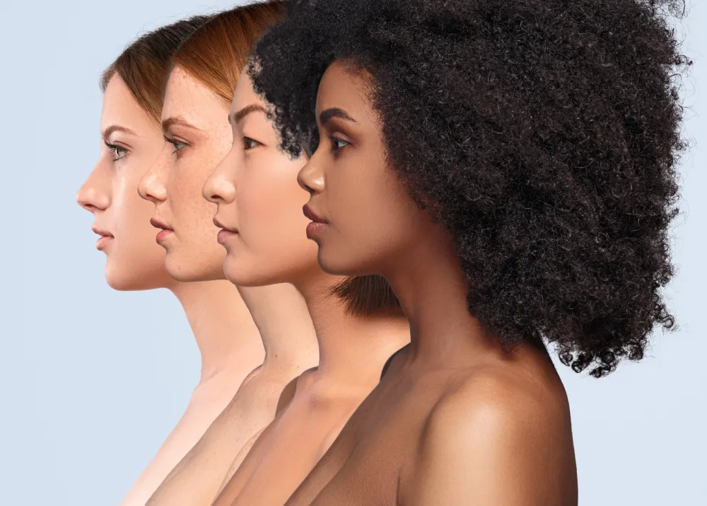 Side profile view of four diverse women with radiant complexions standing in a row, demonstrating the inclusive results of tallow skincare for all skin types and tones during a summer skincare routine.