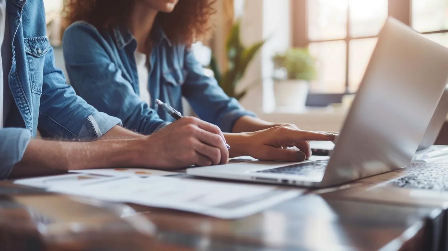 A close-up shot of two people (a homeowner and a contractor) sitting at a table with a laptop, looking at a portfolio or a contract. The image should feel collaborative and trustworthy, with the contractor pointing to a specific detail on the screen or document. The setting should be a clean office or a quiet corner of the construction site trailer.
