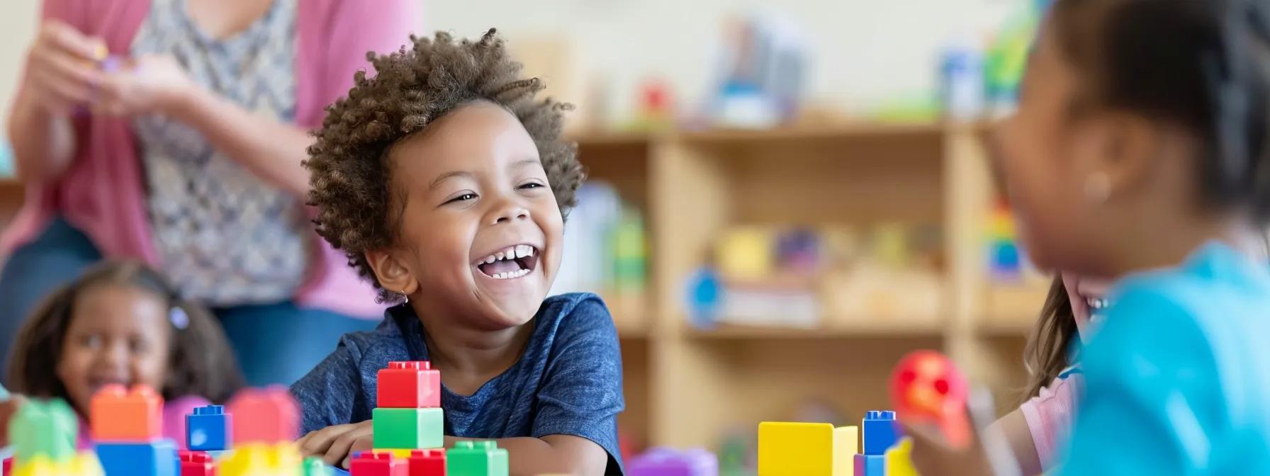 Child smiling joyfully while playing with colorful building blocks in a vibrant early learning environment, illustrating the importance of play in child development at Chroma Early Learning Academy.