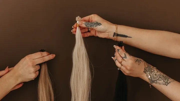 Three hands display strands of different hair extensions, illustrating the preparation stage of a detailed step-by-step Micro Ktip installation process. Three hands display strands of different hair extensions, illustrating the preparation stage of a detailed step-by-step Micro Ktip installation process.