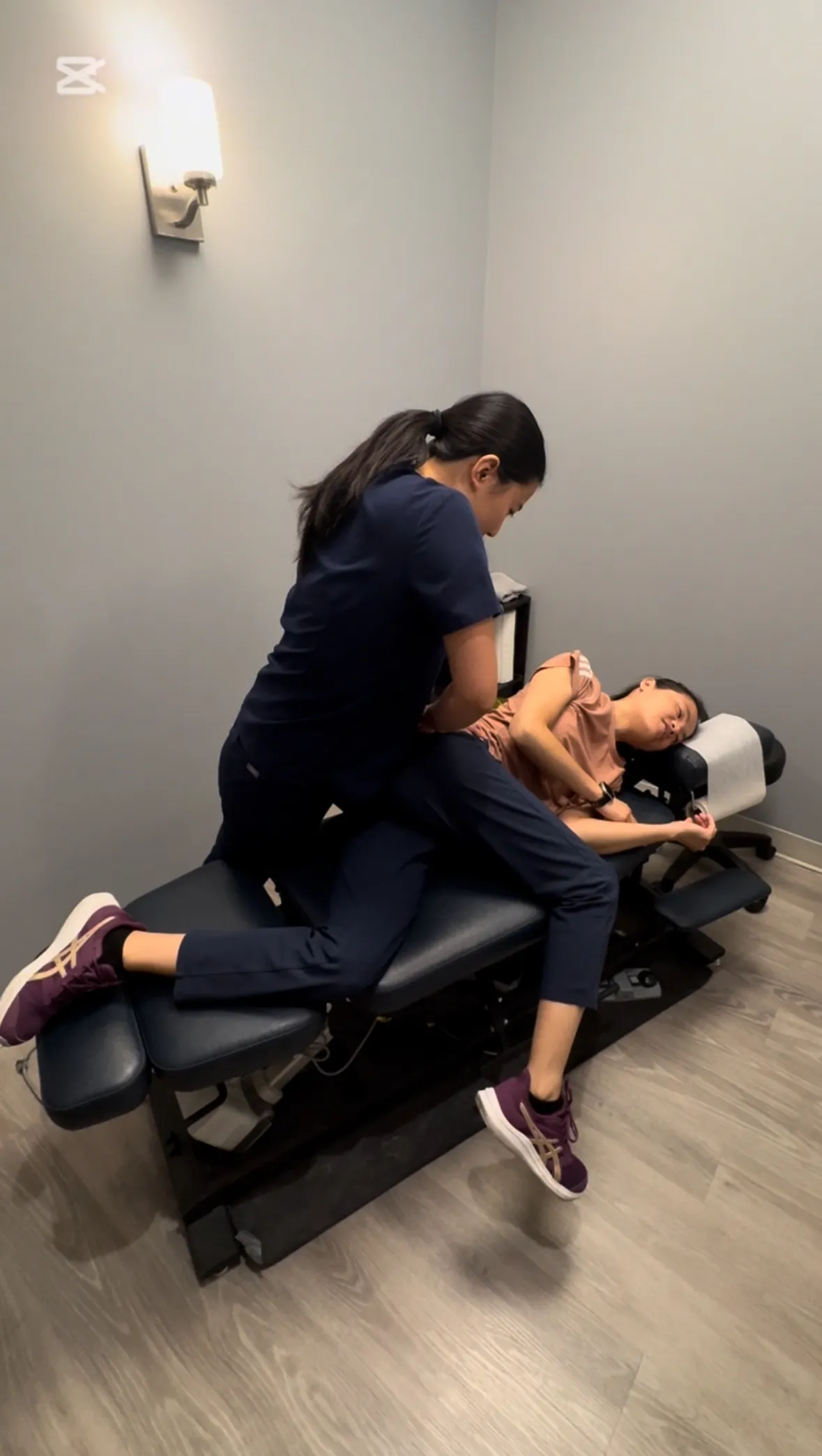 Chiropractor adjusting a patient's back in a calming clinic environment