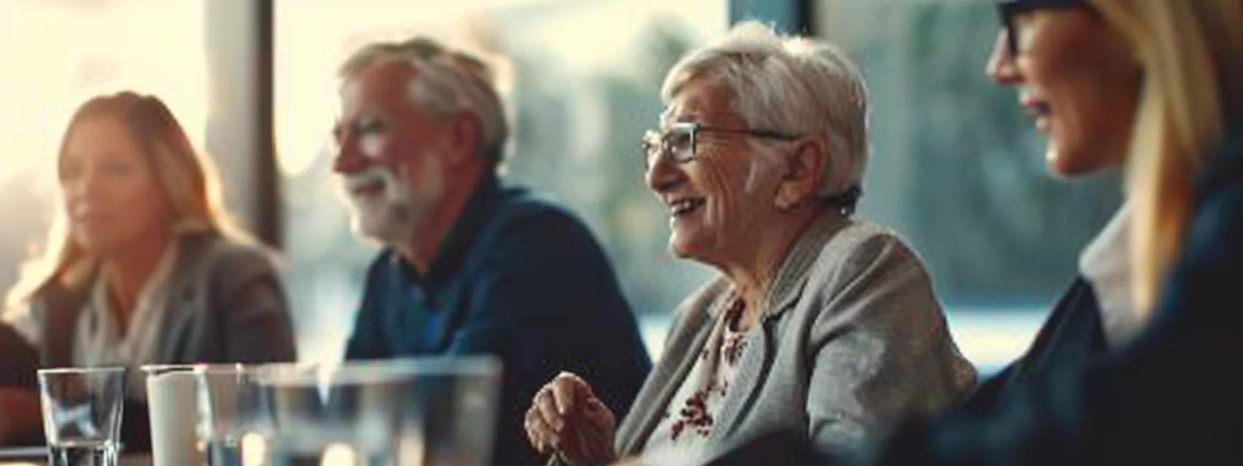 a group of older adults sitting together, discussing affordable and accessible senior life insurance options.