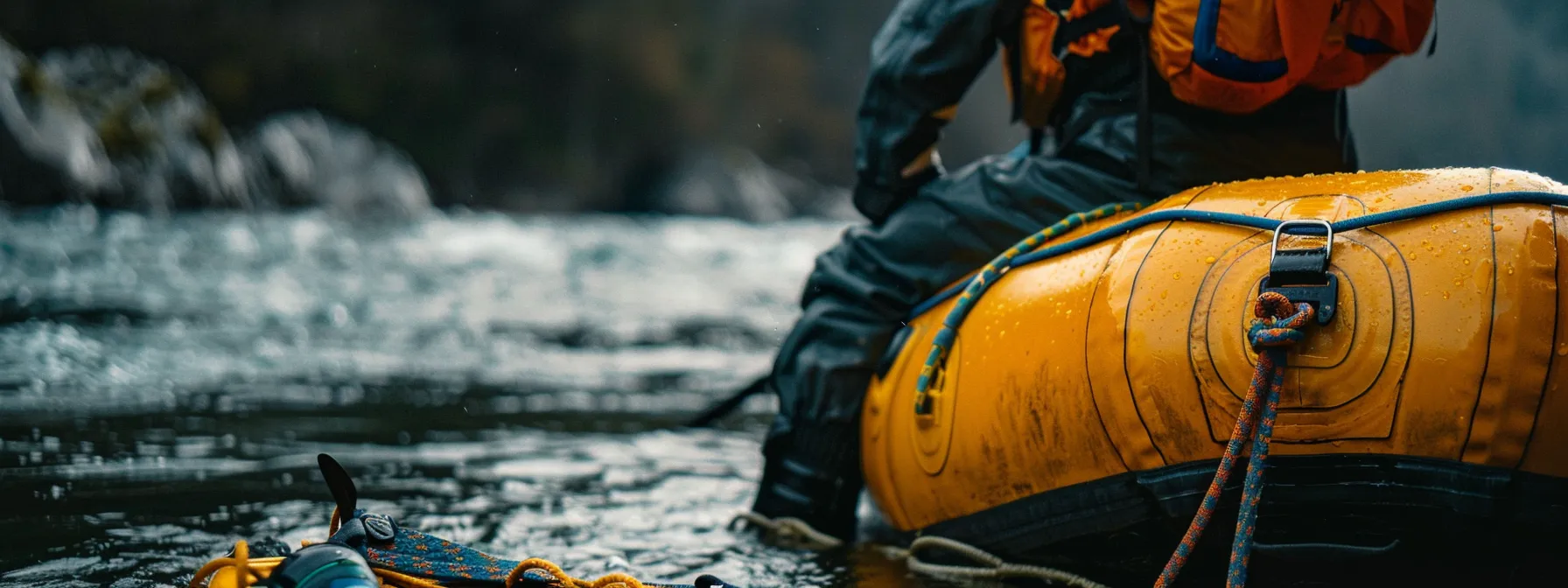 a person kneeling beside a raft, checking safety equipment before embarking on a solo rafting adventure.