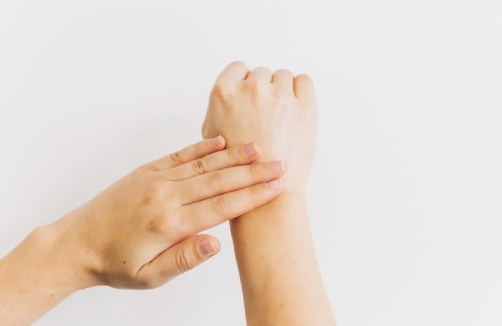 Two hands after applying tallow balm to a wrist and forearm against a white background Two hands after applying tallow balm to a wrist and forearm against a white background
