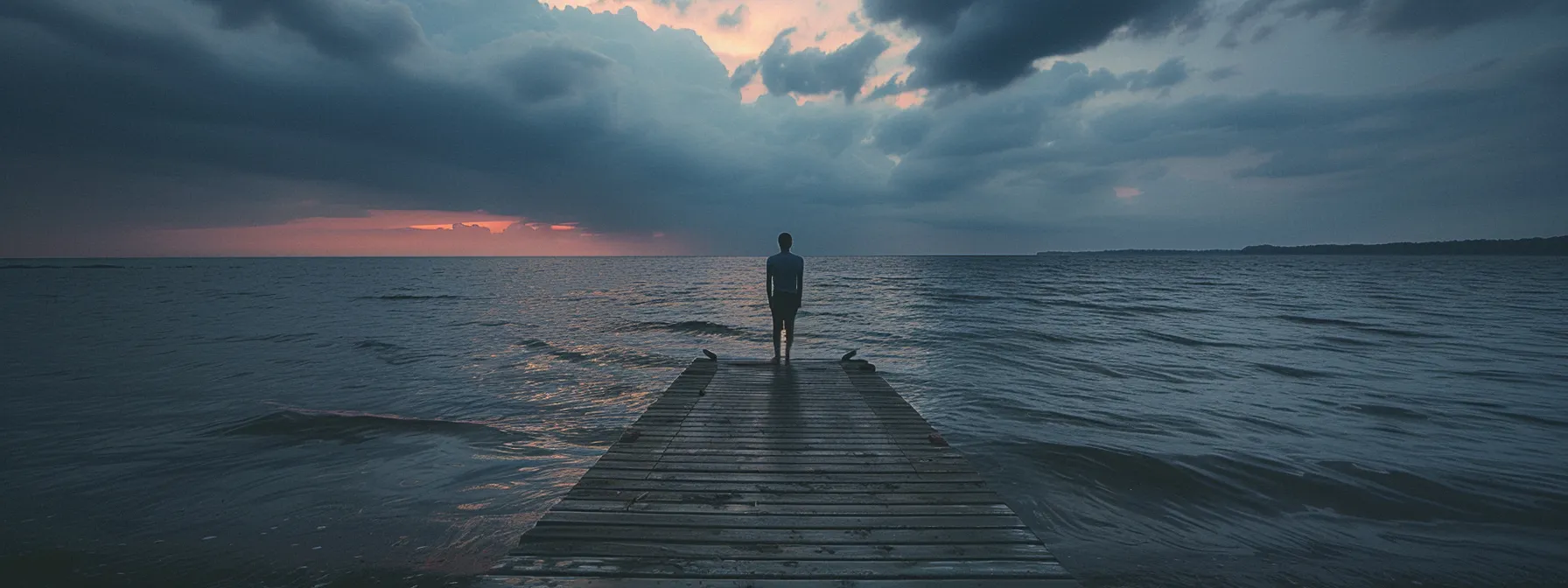 a person standing at the edge of a dock, looking out at the vast ocean with a determined expression.