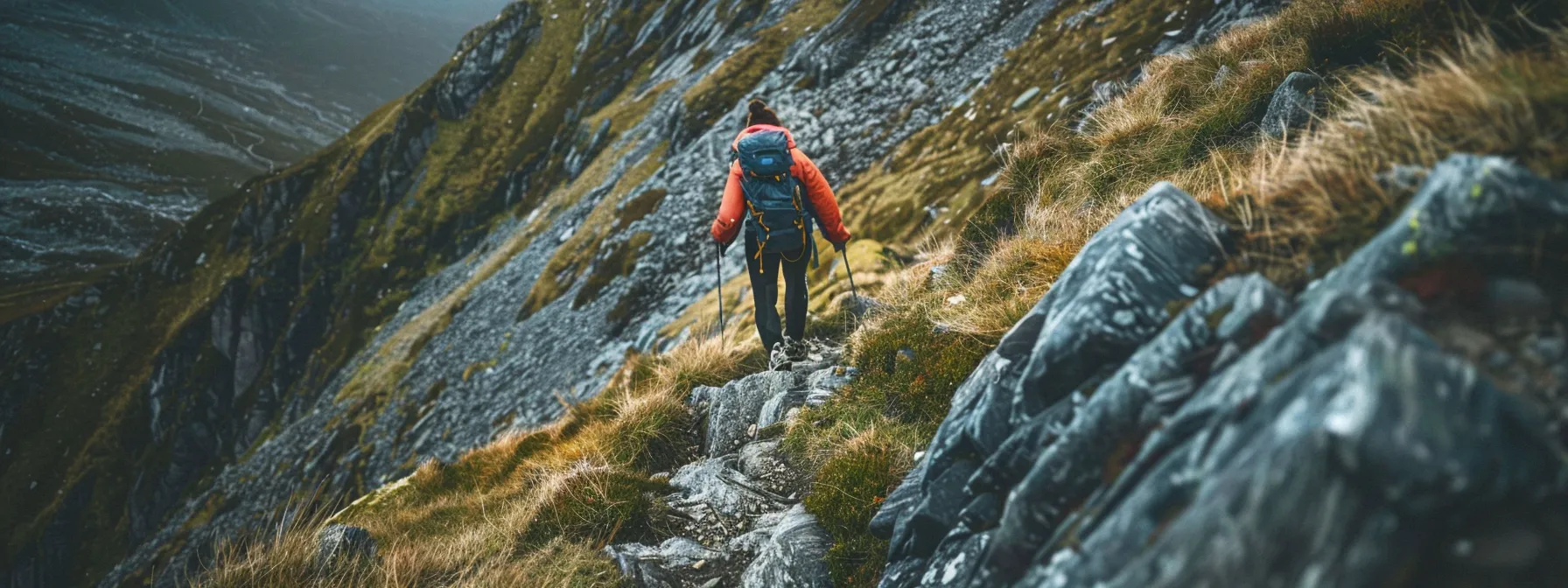 a person scaling a rocky mountain path with determination and focus.