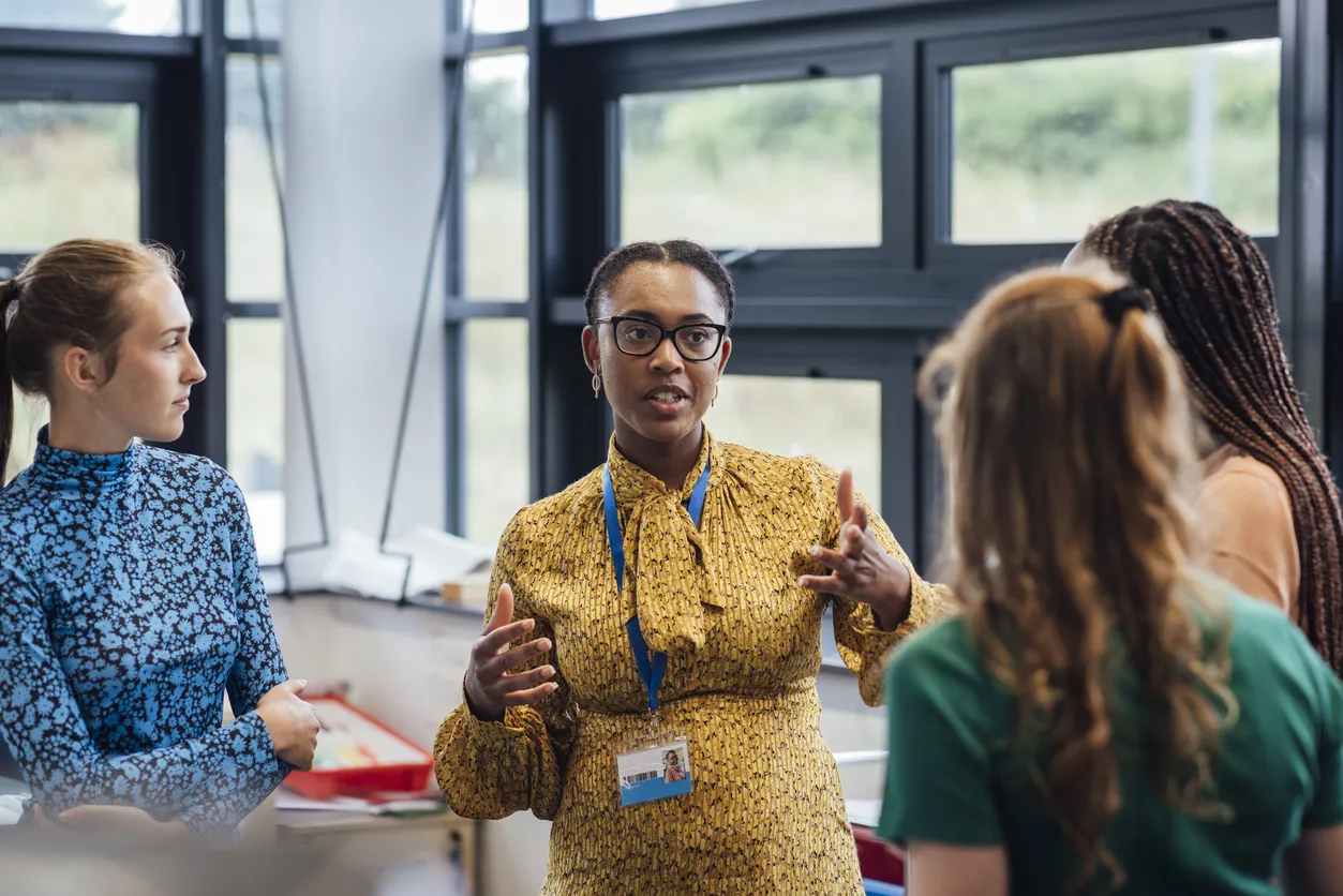 A shot of a people tracing specialist talking with her colleauges, they are wearing casual clothing and discussing people tracing, in the Bluemoon Investigations office in Croydon, England.