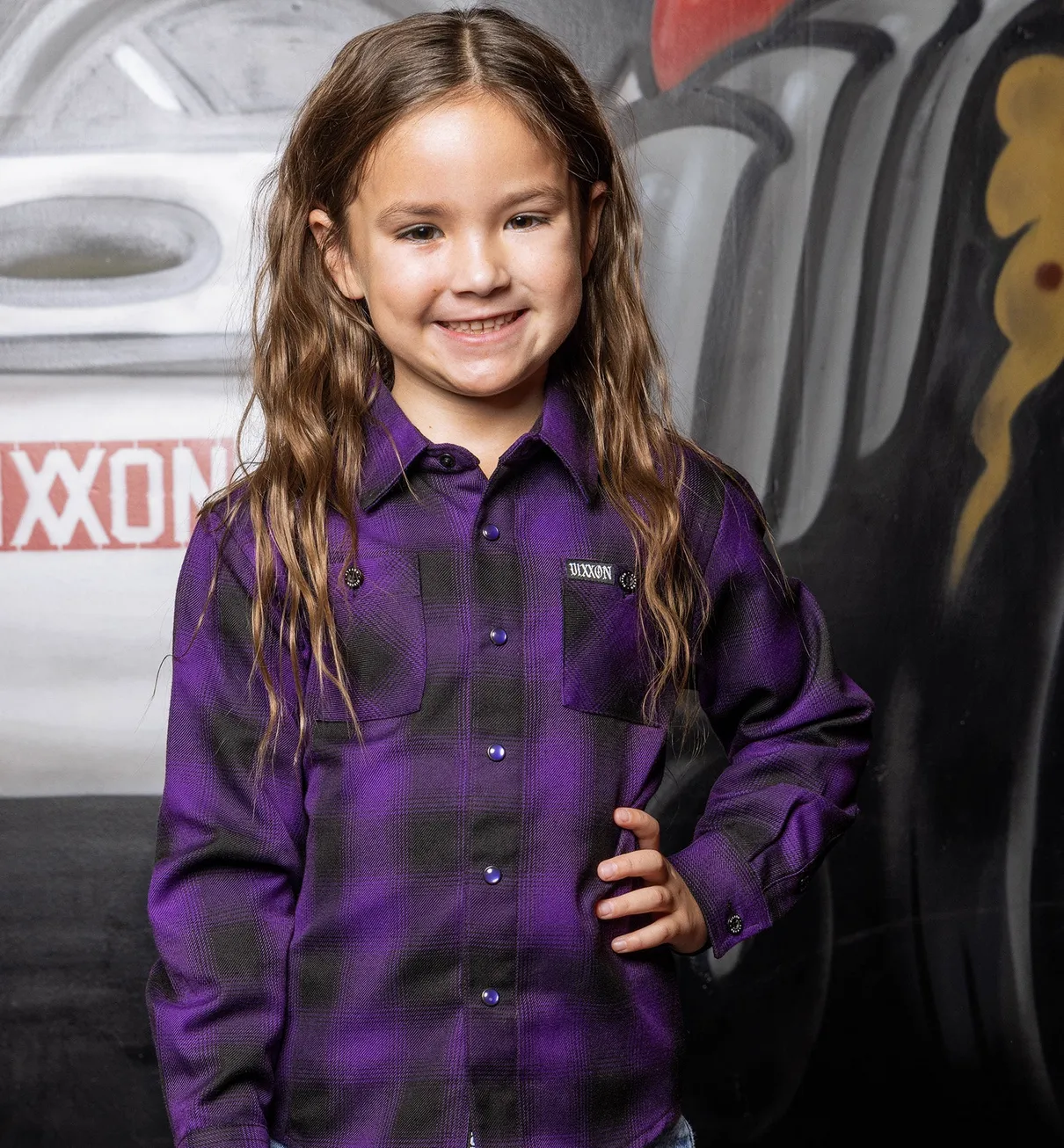 Young girl smiling with her hand on her hip wearing Dixxon Royalty Heritage Flannel