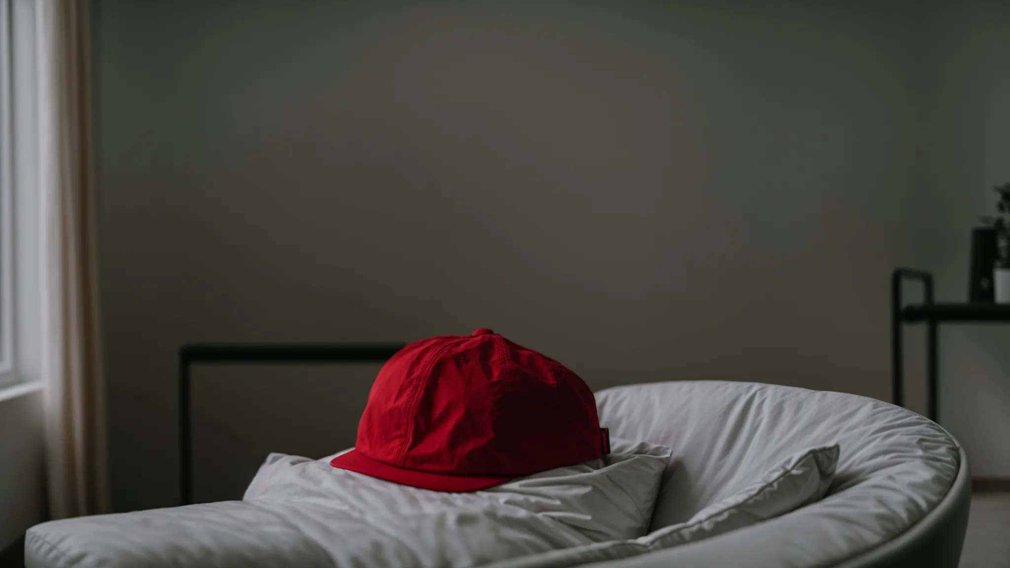 a person wearing a red light therapy cap while relaxing in a chair, surrounded by soft lighting.