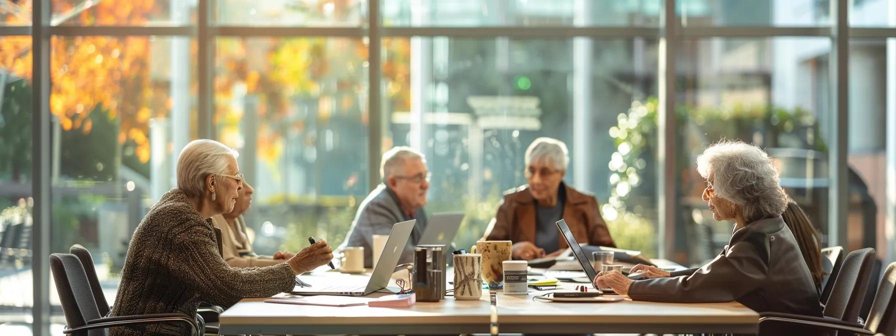 a brightly lit modern office space features a diverse group of older adults engaged in a focused discussion around a large conference table, with laptops and printed materials on the table, symbolizing the strategic navigation of the medicare enrollment process.