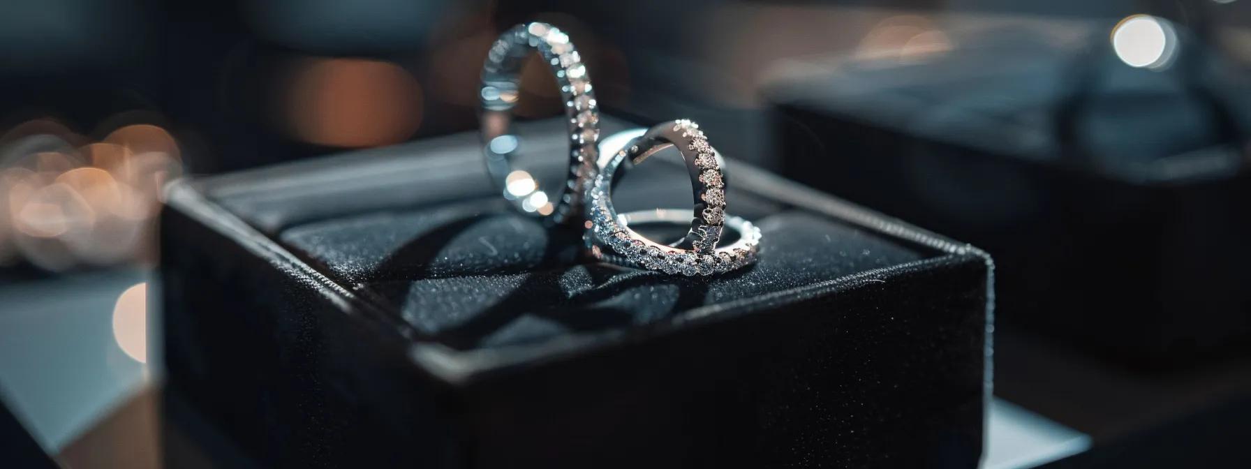 a close-up shot of an elegant display featuring a platinum ring and a white gold ring side by side, set against a sleek black velvet background, highlighting their distinct luster and emphasizing the price disparity in the jewelry market. a close-up shot of an elegant display featuring a platinum ring and a white gold ring side by side, set against a sleek black velvet background, highlighting their distinct luster and emphasizing the price disparity in the jewelry market.