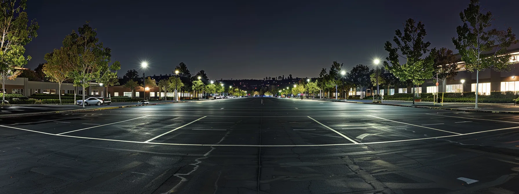 a freshly resurfaced parking lot gleams under bright, artificial lights, showcasing the smooth dark asphalt contrasted against crisp white parking lines, symbolizing maintenance and durability in urban infrastructure.