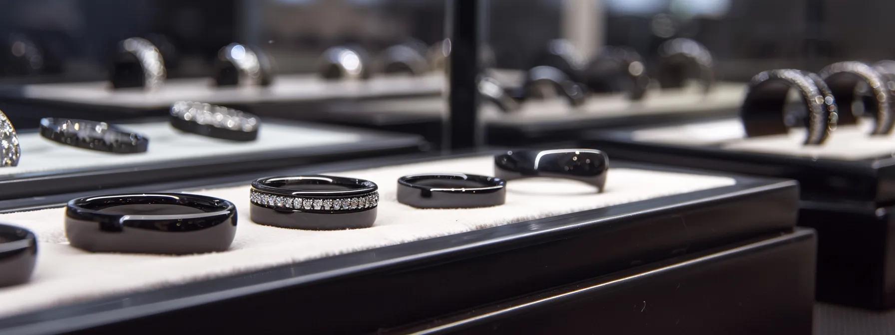 a polished display case showcases an array of elegant black engagement bands made from diverse materials, illuminated by focused lighting that highlights the unique textures and craftsmanship, set against a sleek, modern office backdrop. a polished display case showcases an array of elegant black engagement bands made from diverse materials, illuminated by focused lighting that highlights the unique textures and craftsmanship, set against a sleek, modern office backdrop.
