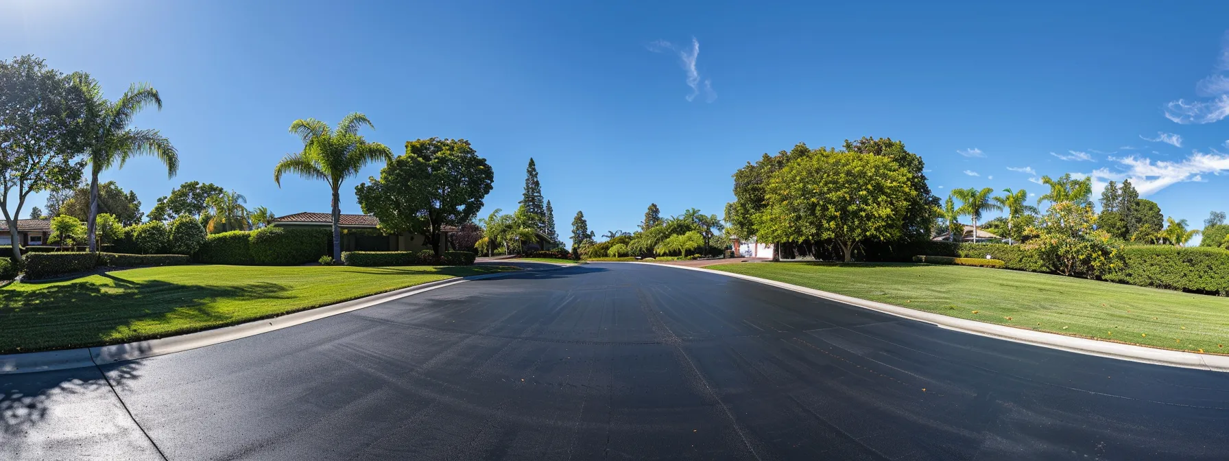 a freshly sealcoated asphalt driveway under a clear blue sky, showcasing vibrant black color and smooth surface. a freshly sealcoated asphalt driveway under a clear blue sky, showcasing vibrant black color and smooth surface.