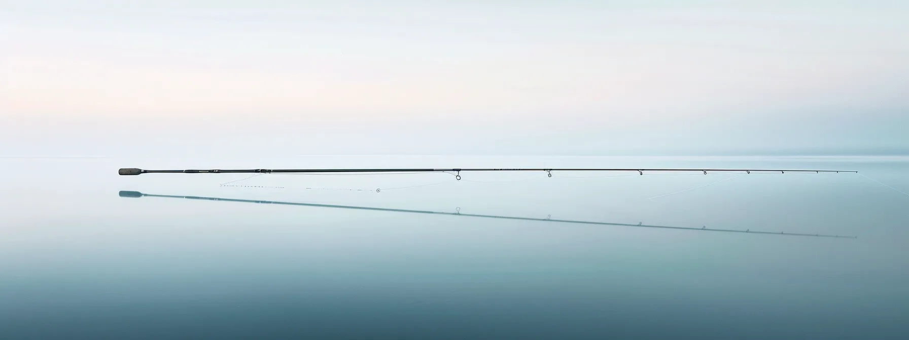 a sleek, graphite fishing rod casting out over a serene body of water, capturing the essence of precision and sensitivity in angling. a sleek, graphite fishing rod casting out over a serene body of water, capturing the essence of precision and sensitivity in angling.