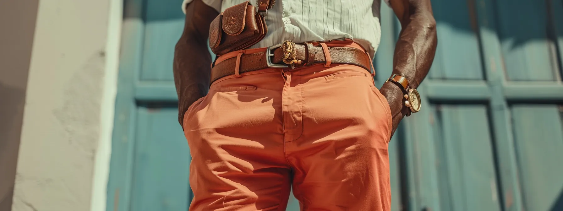 a stylish man with stacked pants accessorized with a sleek belt, statement jewelry, and a trendy bag, showcasing a cohesive and fashion-forward look. a stylish man with stacked pants accessorized with a sleek belt, statement jewelry, and a trendy bag, showcasing a cohesive and fashion-forward look.