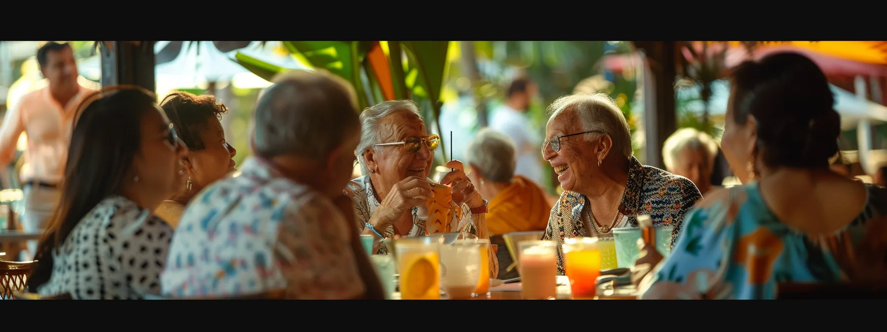 a vibrant café scene captures a diverse group of lively individuals over 50, engaging in animated conversation and laughter at a stylish indoor table, adorned with colorful drinks and modern decor, reflecting a zest for life and connection.